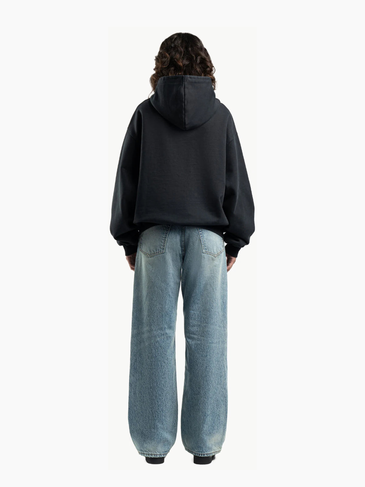 Jean unisexe loose fit en denim 15 oz – Bleu moyen — Porté femme de dos